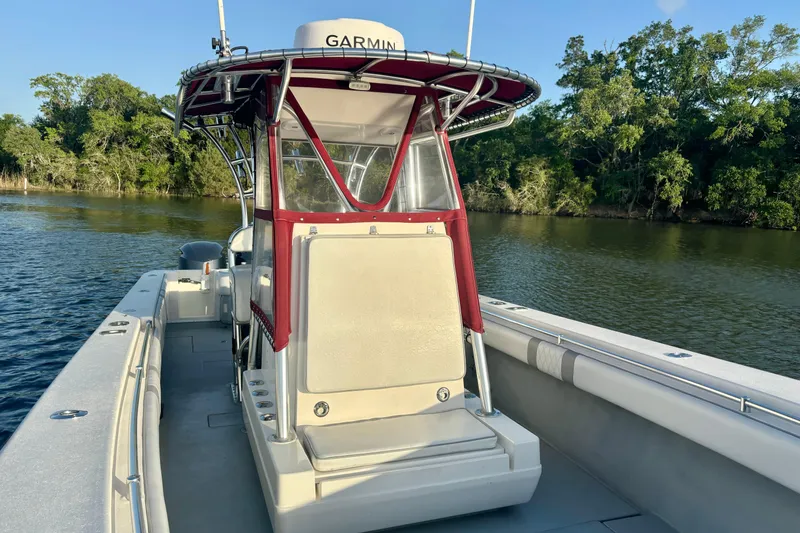 Slide: The Image of 2006 Contender 33 Tournament boat on calm water, featuring Garmin equipment and lush greenery backdrop. - 16