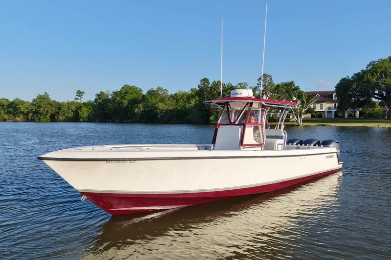 Slide: The Image of 2006 Contender 33 Tournament boat on calm water, surrounded by lush greenery. - 2