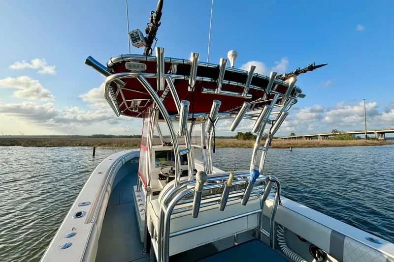 Slide: The Image of 2006 Contender 33 Tournament boat on water, featuring rod holders and a clear sky backdrop. - 20