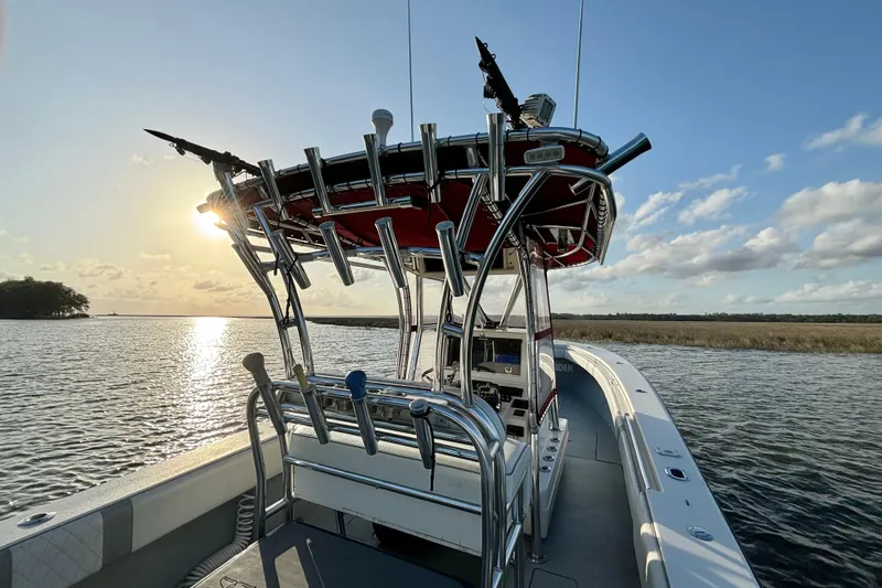 Slide: The Image of 2006 Contender 33 Tournament boat on water at sunset, featuring fishing rod holders. - 21