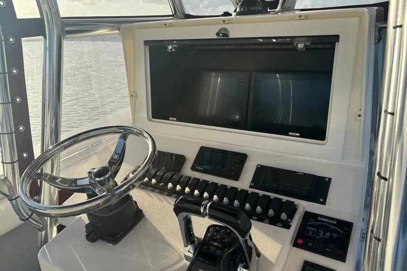 Slide: The Image of Helm of 2006 Contender 33 Tournament boat with steering wheel and navigation controls. - 26
