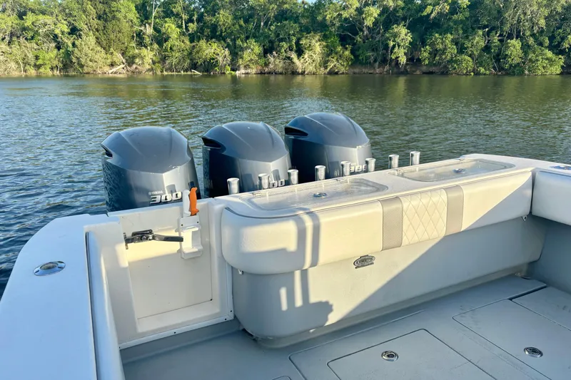 Slide: The Image of 2006 Contender 33 Tournament boat with triple Yamaha engines on a calm river. - 28