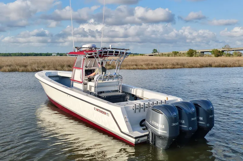 Slide: The Image of 2006 Contender 33 Tournament boat with triple Yamaha engines on calm water. - 6