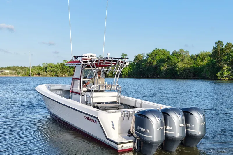 Slide: The Image of 2006 Contender 33 Tournament boat with triple Yamaha engines on a calm lake. - 7