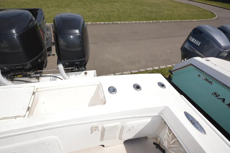 Slide: The Image of 2009 Steiger Craft 26 Miami boat with dual outboard motors, parked on a paved area. - 11