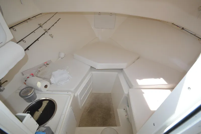 Slide: The Image of 2009 Steiger Craft 26 Miami cabin interior with fishing rods and compact kitchenette. - 24