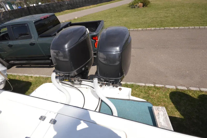 Slide: The Image of 2009 Steiger Craft 26 Miami boat with dual outboard motors, parked near a pickup truck. - 28