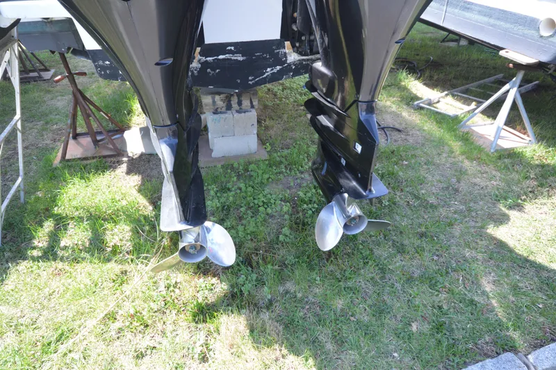 Slide: The Image of Twin outboard motors of a 2009 Steiger Craft 26 Miami boat on grass. - 31