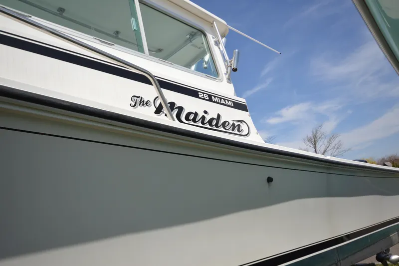 Slide: The Image of 2009 Steiger Craft 26 Miami boat with "The Maiden" name, under a clear blue sky. - 5