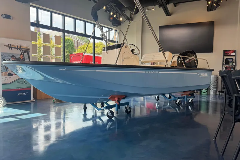 The Image of 2026 Boston Whaler 150 Montauk boat displayed indoors on wheeled stands. - 0