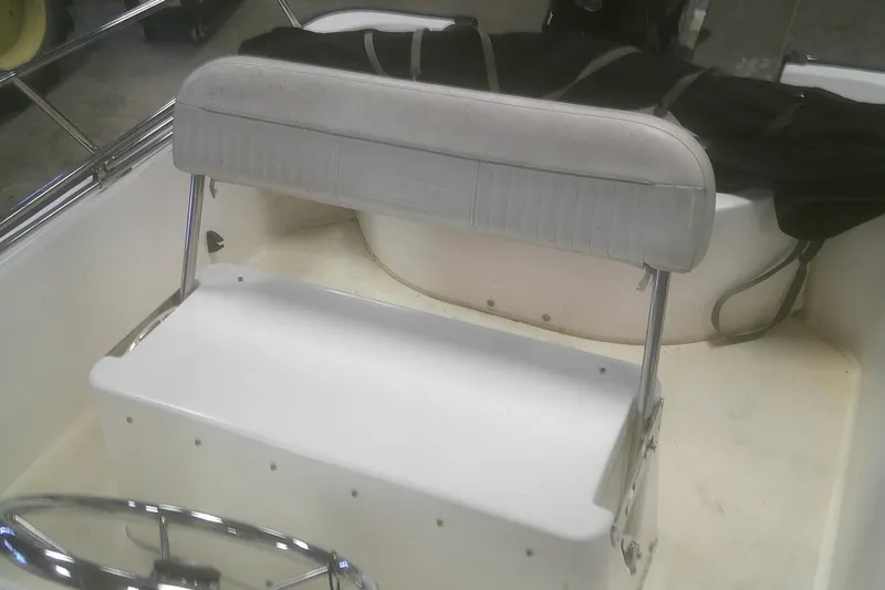 Slide: The Image of 2012 Boston Whaler 150 Montauk boat interior with seating and steering wheel. - 11