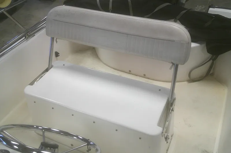Slide: The Image of 2012 Boston Whaler 150 Montauk boat interior with steering wheel and seating. - 12