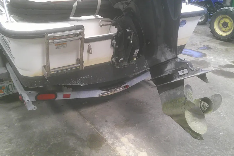 Slide: The Image of Rear view of a 2012 Boston Whaler 150 Montauk boat with visible propeller and ladder. - 15
