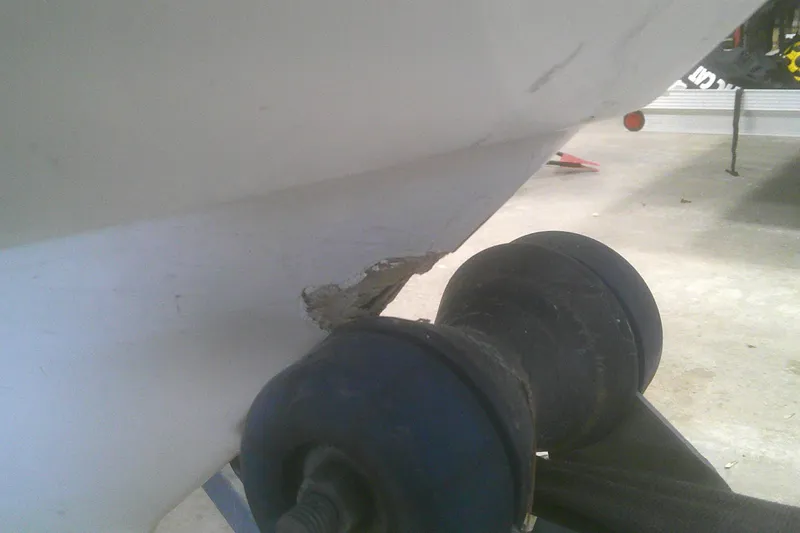 Slide: The Image of Damaged hull of 2012 Boston Whaler 150 Montauk boat on trailer roller. - 19