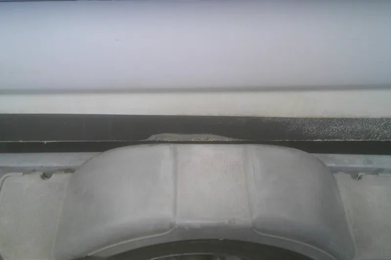Slide: The Image of Close-up of a 2012 Boston Whaler 150 Montauk boat detail, showing hull and trailer. - 22