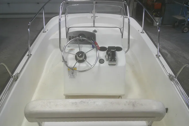 Slide: The Image of 2012 Boston Whaler 150 Montauk boat interior with steering console and seating. - 5