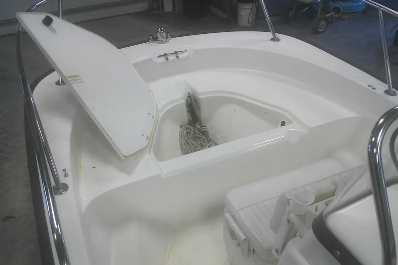 Slide: The Image of 2012 Boston Whaler 150 Montauk boat interior with open storage compartment. - 6