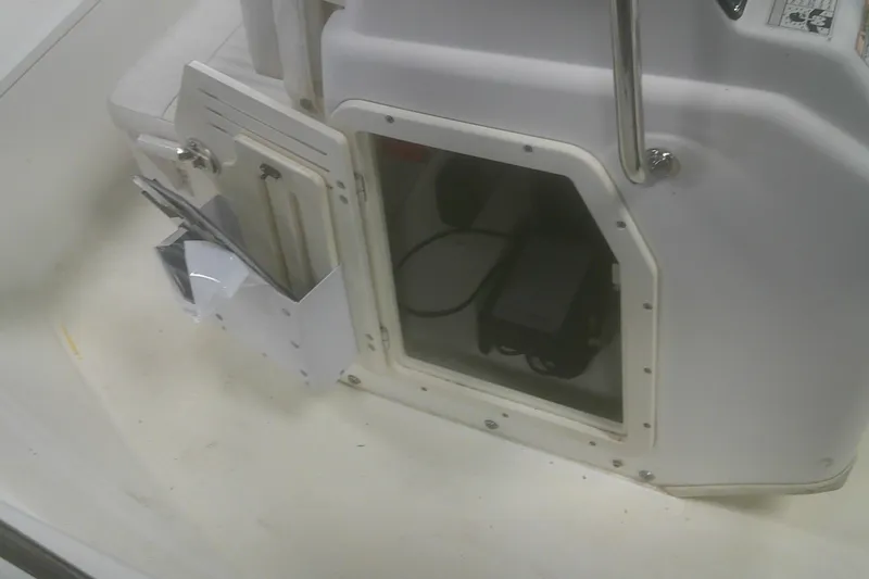 Slide: The Image of 2012 Boston Whaler 150 Montauk interior storage compartment with visible equipment and documents. - 9