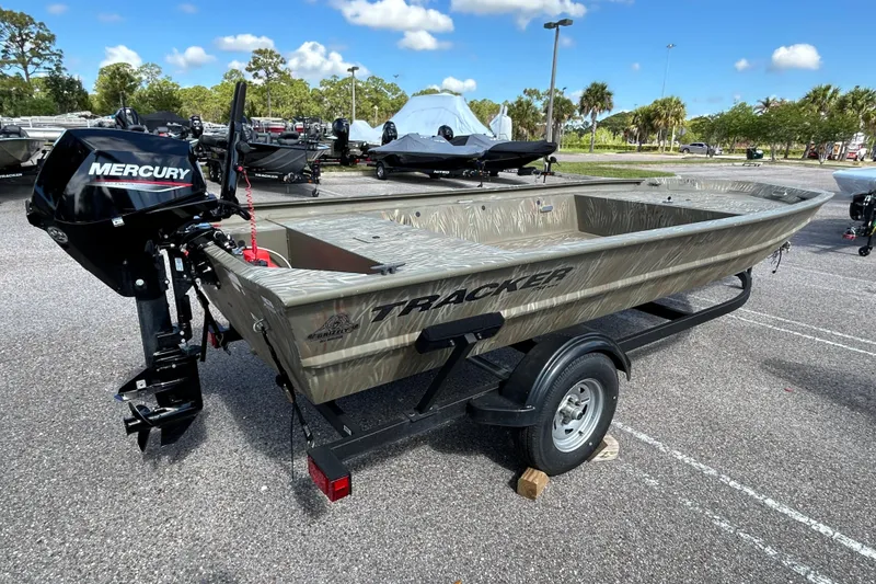 The Image of 2025 Tracker Grizzly 1754 Jon boat with Mercury engine on trailer in parking lot. - 0
