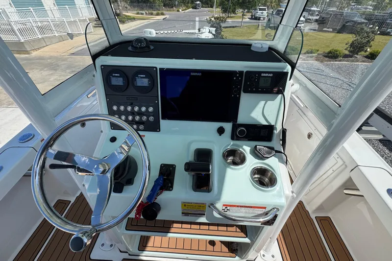 Slide: The Image of 2020 Crevalle 24 HCO boat helm with steering wheel, controls, and navigation displays. - 16