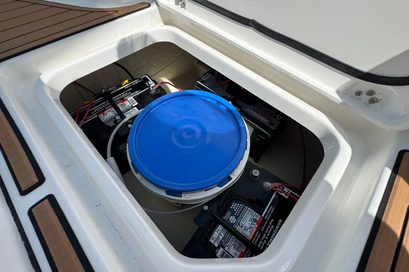 Slide: The Image of 2020 Crevalle 24 HCO boat battery compartment with blue bucket and wiring. - 24