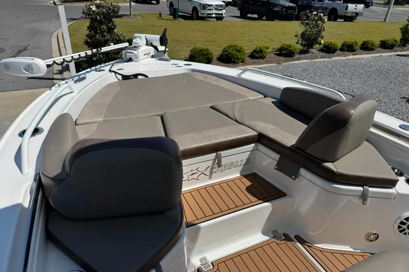 Slide: The Image of 2020 Crevalle 24 HCO boat with cushioned seating and deck, parked outdoors. - 29