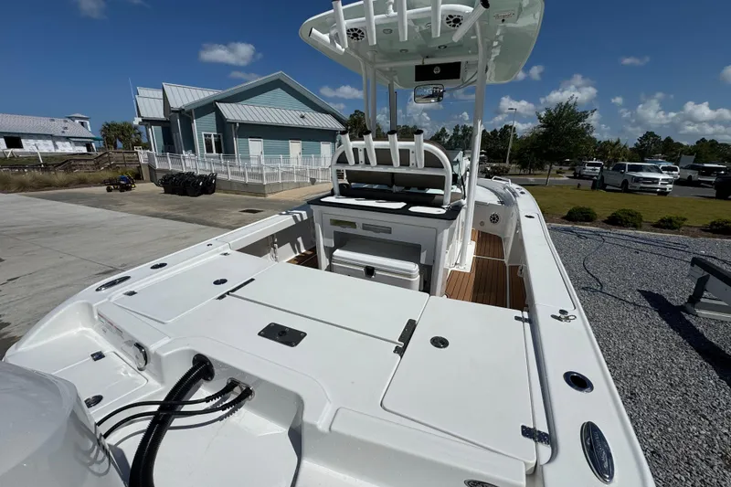 Slide: The Image of 2020 Crevalle 24 HCO boat docked, showcasing spacious deck and seating under clear blue sky. - 8