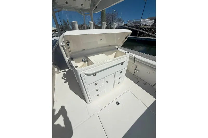 Slide: The Image of 2017 Regulator 31 boat with open storage compartment and drawers, docked under clear blue sky. - 13