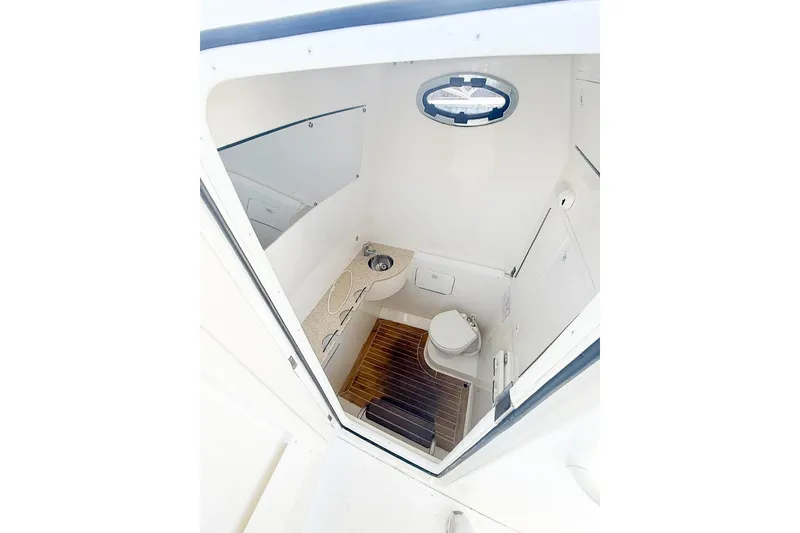 Slide: The Image of 2017 Regulator 31 boat interior with compact bathroom, featuring toilet and sink. - 17