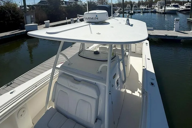 Slide: The Image of 2017 Regulator 31 boat docked, featuring Garmin equipment and spacious seating. - 24