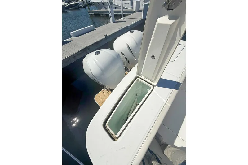 Slide: The Image of 2017 Regulator 31 boat with open storage compartment and twin Yamaha engines at dock. - 7