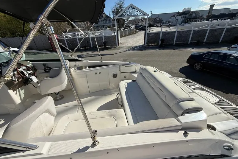 Slide: The Image of 2012 Sea Ray 260 Sundeck boat interior with white seating and steering wheel. - 6