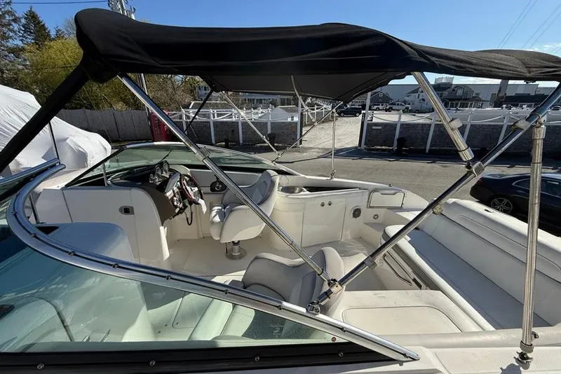 Slide: The Image of 2012 Sea Ray 260 Sundeck boat interior with canopy, featuring steering wheel and seating. - 7