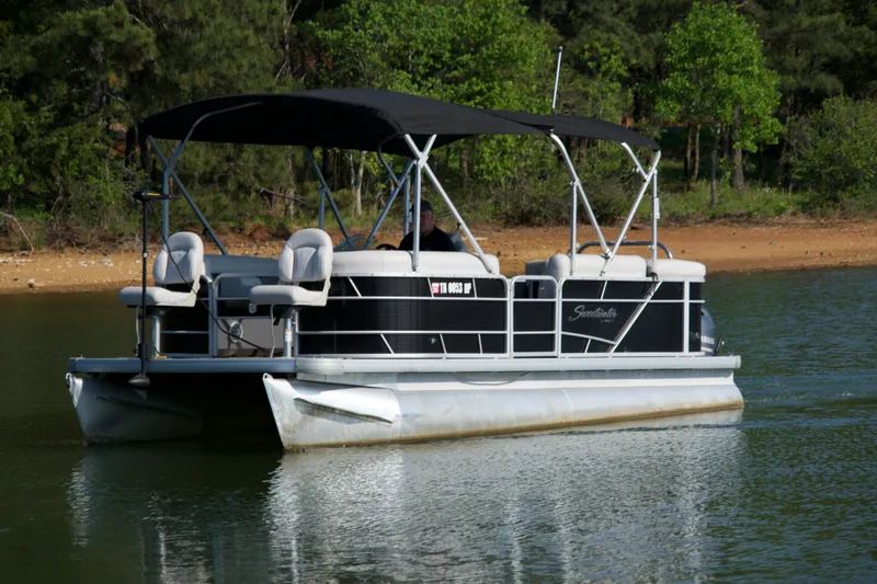 Slide: The Image of 2018 Godfrey Sweetwater20 pontoon boat cruising on a serene lake. - 17