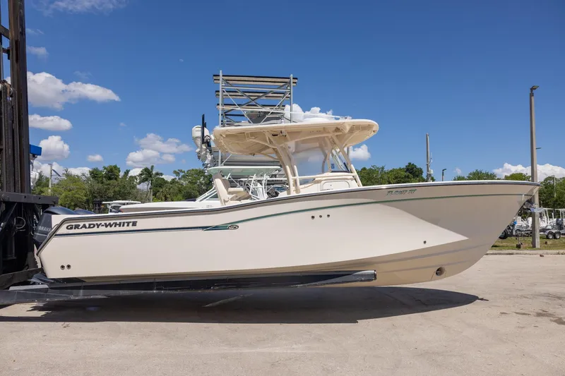 The Image of 2016 Grady-White Canyon 306 boat on a lift under a clear blue sky. - 0