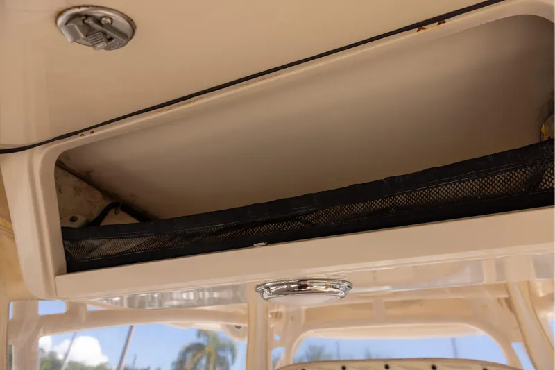 Slide: The Image of 2016 Grady-White Canyon 306 boat storage compartment with netting and latch. - 13