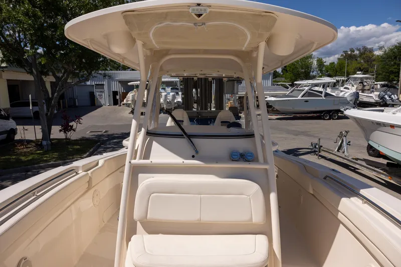 Slide: The Image of 2016 Grady-White Canyon 306 boat interior with seating and helm, docked outdoors. - 18