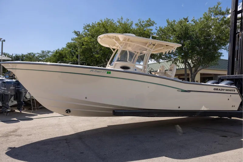 Slide: The Image of 2016 Grady-White Canyon 306 boat on display, side view with trees in background. - 5
