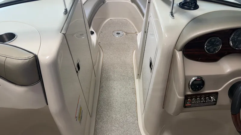 Slide: The Image of The image shows the interior of a 2007 Sea Ray 200 Sundeck boat. It features light upholstery and a dashboard with multiple gauges. - 45