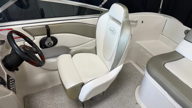 Slide: The Image of Interior of a 2007 Sea Ray 200 Sundeck with beige and gray seating and steering wheel. - 36
