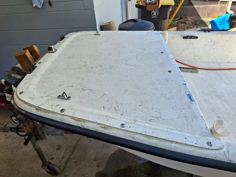 Slide: The Image of 1994 Carolina Skiff J boat with worn deck in a garage. - 4