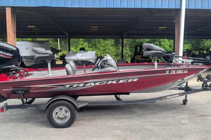 The Image of 2023 Tracker Pro Team 175 TF boat on trailer, parked under a blue-roofed shelter. - 0