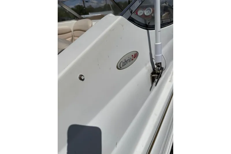 Slide: The Image of 2005 Larson Cabrio 240 boat side view with logo and interior glimpse. - 10
