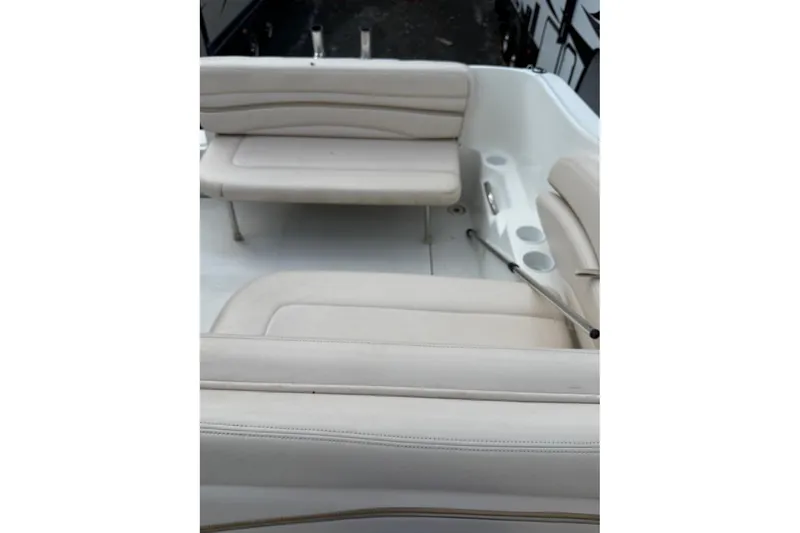 Slide: The Image of 2005 Larson Cabrio 240 boat interior with beige seating and cup holders. - 8