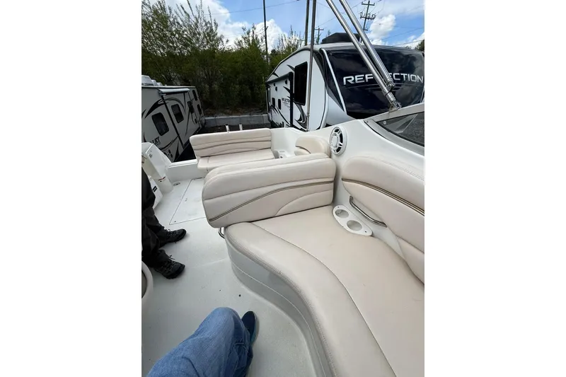 Slide: The Image of 2005 Larson Cabrio 240 boat interior with beige seating and cup holders. - 9