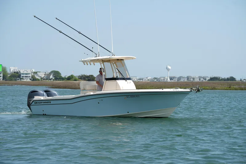 The Image of 2023 Grady-White Fisherman 257 boat cruising on calm waters near shoreline. - 1