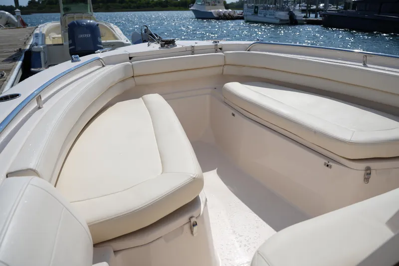 Slide: The Image of 2023 Grady-White Fisherman 257 boat interior with cushioned seating, docked by the water. - 31