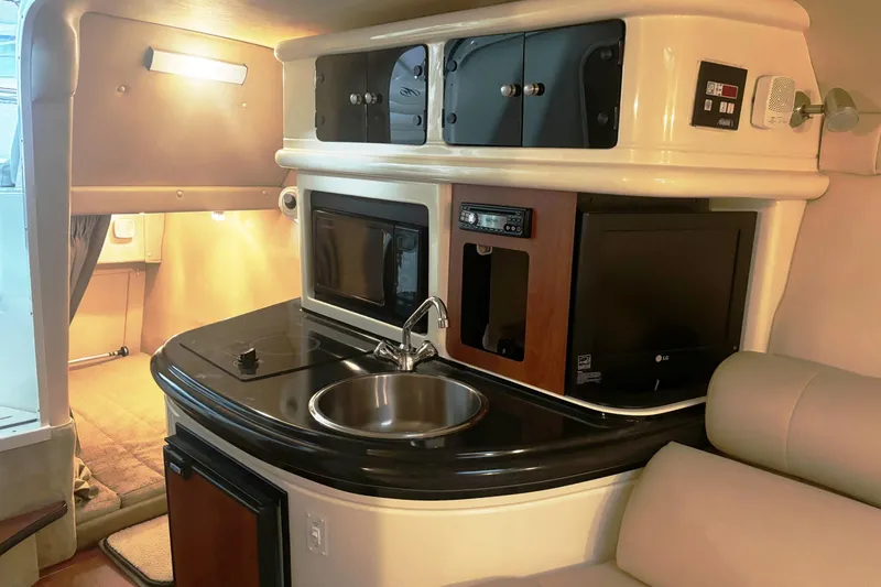 Slide: The Image of Interior of a 2008 Monterey 250 Cruiser boat with kitchenette and seating area. - 14
