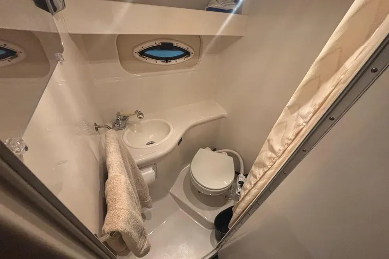Slide: The Image of Compact bathroom in 2008 Monterey 250 Cruiser boat with sink, toilet, and porthole. - 15