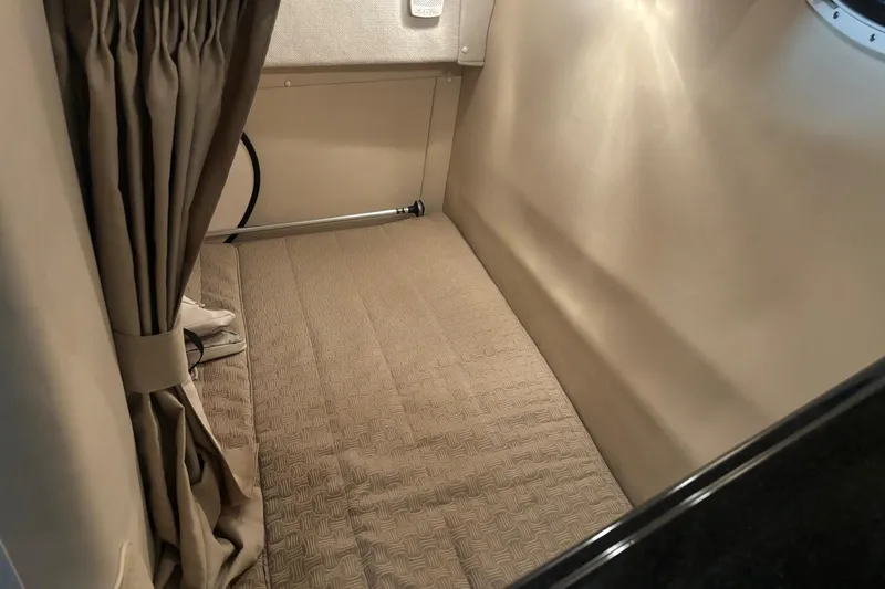 Slide: The Image of Interior cabin of a 2008 Monterey 250 Cruiser with beige bedding and curtains. - 16